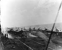 Photo # 80-G-16802:  View on USS Lexington's flight deck, as fires burn in her hangar, 8 May 1942