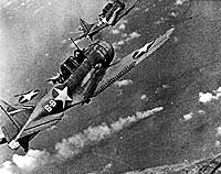 Photo # 80-G-17054: SBD bombers from USS Hornet approach the burning Japanese cruiser Mikuma, during the Battle of Midway, 6 June 1942