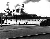 Photo # 80-G-32443: USS Nevada heading down the Pearl Harbor Channel during the Japanese raid, 7 December 1941.