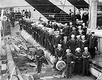 Photo # NH 41945:  Officers and men of USS West Hosokie pose with a 14-inch gun stowed on deck, circa 10 March 1919.  Photographed by Charles M. Clark