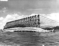 Photo # NH 63916:  Rolling USS Oklahoma upright, while she was under salvage at Pearl Harbor on 8 March 1943.