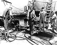 Photo # NH 64303:  Members of the diving crew emerge from water-filled compartments of the sunken battleship Arizona, 25 May 1943.