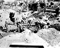 Photo # NH 96662:  Workmen clearing away bomb damage debris near Dry Dock Number One, Pearl Harbor Navy Yard, after the 7 December 1941 Japanese raid.