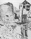 Signal Corps Troops in Domfront repair wires cut by the Germans