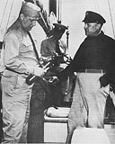 Ill. 10. First inspection (courtesy) of 1947 at Milwaukee Yacht Club. 
Left to right: Hilmar W. Beose, Vice Comm. Area M&S. 
Harvey Maresch, Flotilla 24-07 Inspection Committee, awarding first decal (CG-2902) 
to Harry E. Sanger, Vice Captain, Division XXIV, on Sanger's Vessel 'Rendezvous'