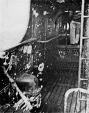 Photo 12-3: Fragmentation damage, port bulwark, forward end of cigarette deck